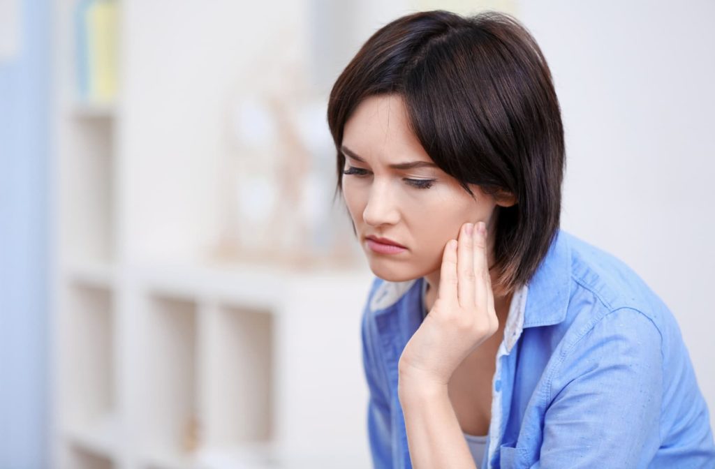 Woman touching her jaw because of bruxism pain