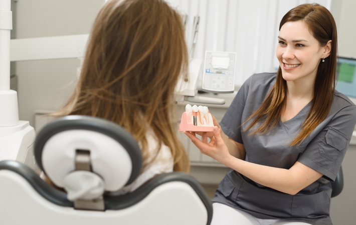 A patient having a consultation with her dentist about undergoing a dental implant procedure