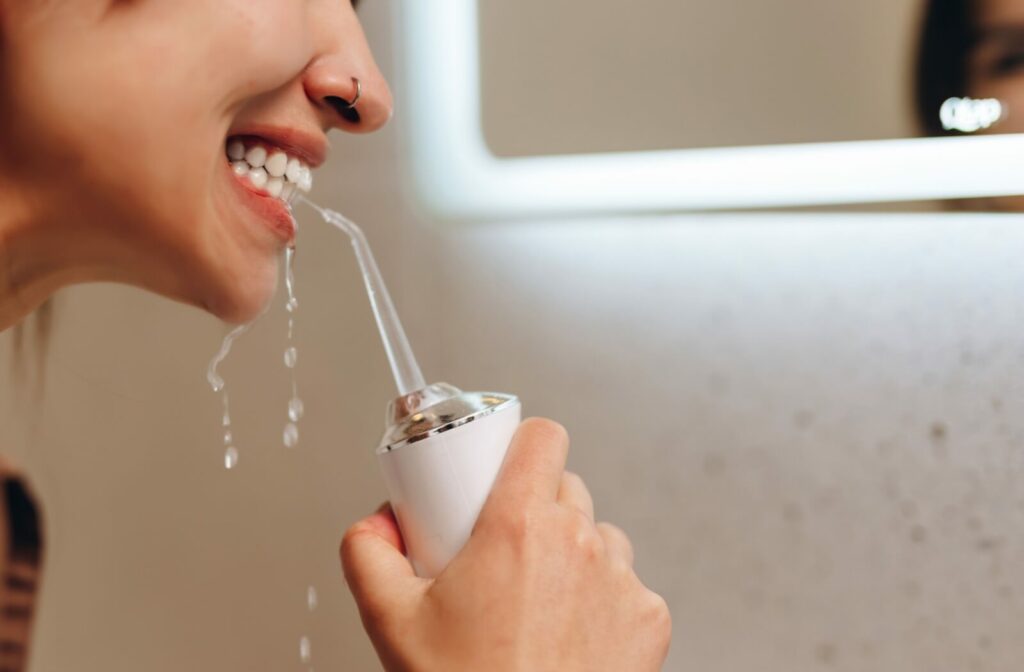 A person demonstrates how a Waterpik gently cleans hard-to-reach areas using water.