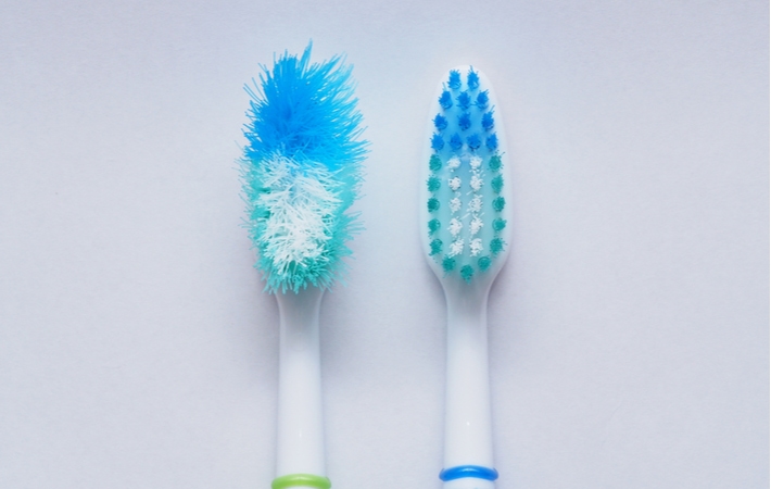 A comparison between a new manual toothbrush and an identical one but with extremely frayed bristles from aggressive brushing