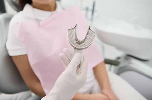 A female patient is about to get impressions on her teeth for her dentures.