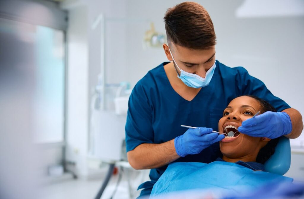 A dentist closely examines their patient's mouth to look for any signs of tooth decay or cavities.