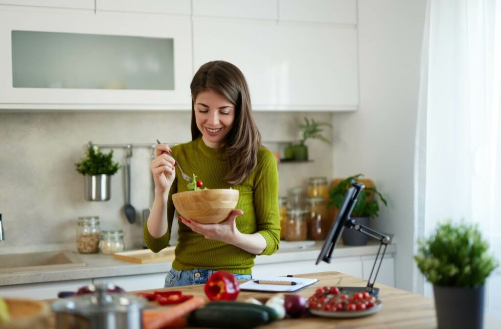 A woman eating soft healthy food that will help recover after dental implants