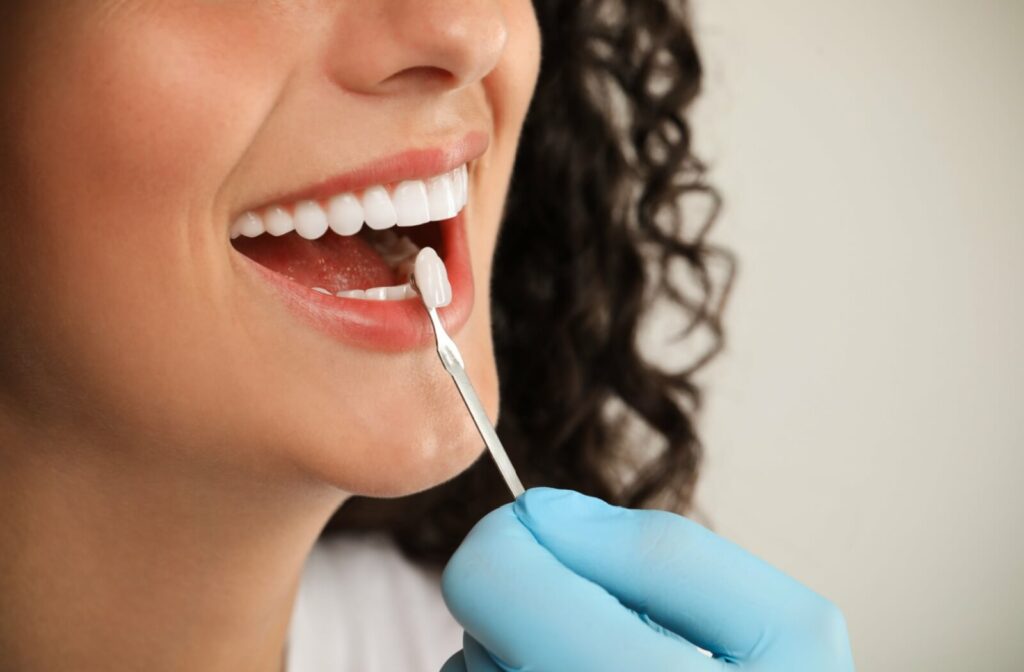 a person at a dental appointment matching veneer colour to their tooth.