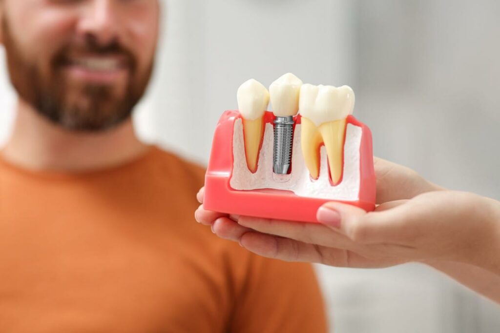A dental implant 3D model being held in front of a patient