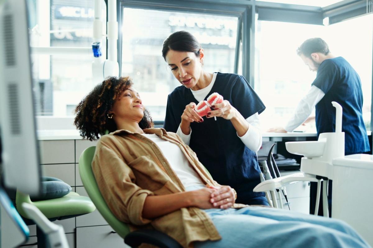 a person being shown how a dental implant works via a 3D model